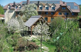 Ein Hotel im Dirndltal mit bl&uuml;henden B&auml;umen und Garten.