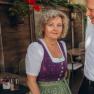Eine Frau in traditioneller Kleidung steht neben einem Mann in einem wei&szlig;en Hemd mit Aufschrift.