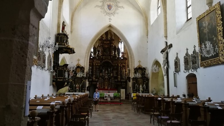 Innenansicht einer Wallfahrtskirche mit Altar, B&auml;nken und religi&ouml;sen Kunstwerken.
