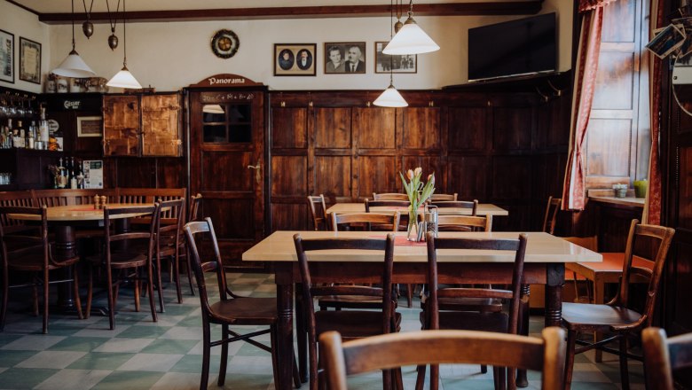Gemütliches, traditionelles Gasthaus mit Holzmöbeln und dekorativen Bildern.